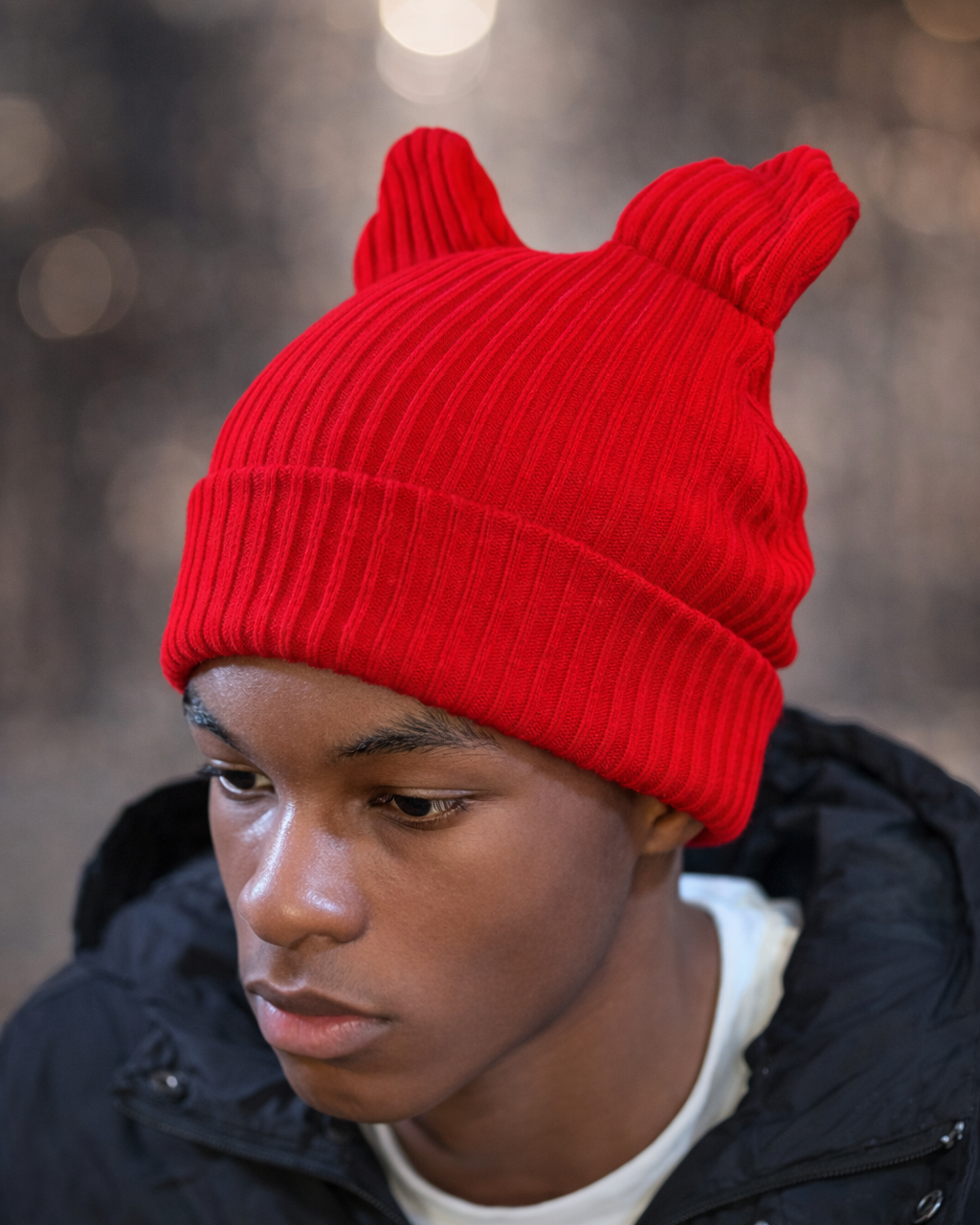 Person wearing a red beanie with cat ears against a blurred background