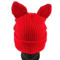 Red knitted hat with bunny ears on a mannequin head against a white background